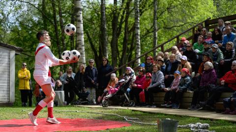 Sirkustaiteilija jongleeraa palloja.