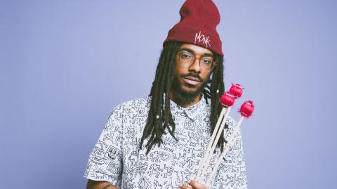 Joel Ross, vibraphone mallets in hand and a Monk beanie on his head.