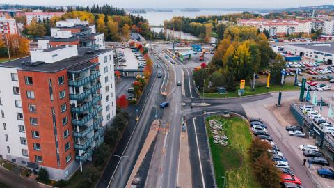 Kuvassa raitiotietyömaa, katua, taloja ja pysäköityjä autoja. 