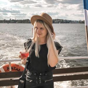 Victoria Laaksonen on a boat with Finnish flag next to her