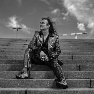 Mies istuu kiviportailla.