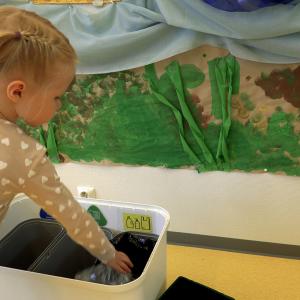 A little girl sorts rubbish in a daycare centre