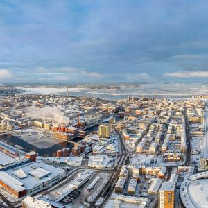 Ilmakuva talvisesta Tampereen kaupungin keskustasta ja taustalla sininen taivas.