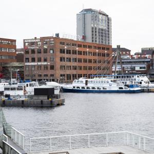 Laukontorin satamassa muutamia veneitä ankkurissa ja taustalla näkyy punatiilisiä rakennuksia sekä taustalla korkea rakennus.