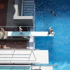 Children on the diving board at Outdoor swimming pool.