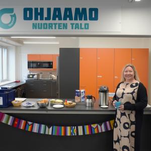 Nainen toimistotilan kahvipisteen edessä.