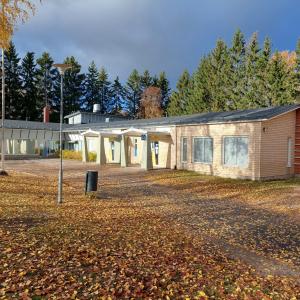 Keltainen rakennus, taustalla metsää.