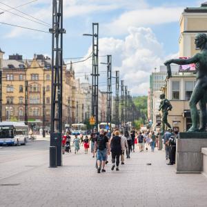 Ihmiset kävelevät Hämeensillalla. Taustalla busseja.