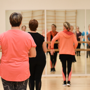 Kolme henkilöä tanssisalissa.