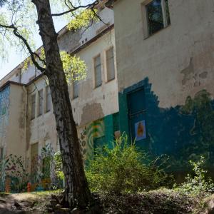 Entinen Pyynikin sairaala on huonokuntoisen näköinen rakennus, jonka ulkoseinissä on graffiteja.