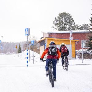 Pyöräilijät pyöräilevät talvisessa säässä.
