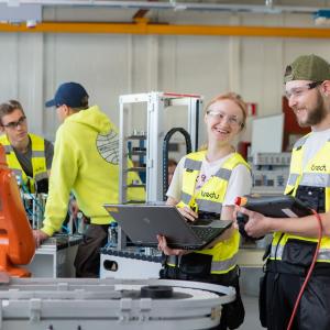 Ammatillisen koulutuksen opiskelijat juttelevat koneiden ääressä.