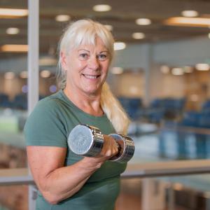 Iloinen nainen käsipaino kädessä 