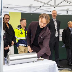 Ilmari Nurminen puts an object into a time capsule during the ceremony.