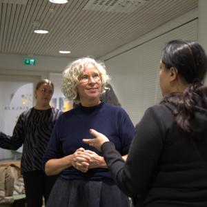 Vaalea- ja tummahiuksinen nainen keskustelevat. 