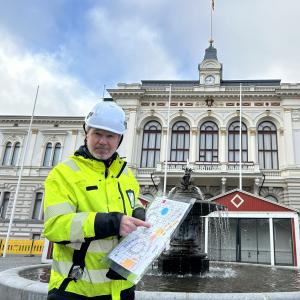 Christmas Market&#039;s producer Rami Lehtinen shows a map of the Christmas Market area. The Christmas Market is under construction in the background.