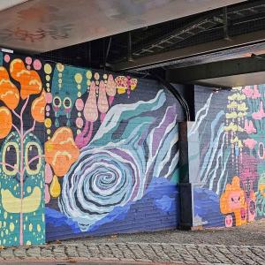 A colourful art wall under the bridge.