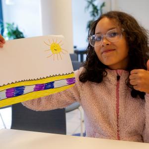 Nuori näyttää piirustustaan kameralle.