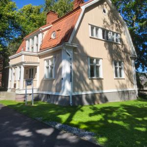 Alilääkärin entisen asuintalon seinät ovat keltaiset ja kulmikas katto on punatiilinen.