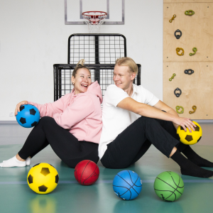 Mustametsän päiväkodin kaksi varhaiskasvatuksen lastenhoitajaa liikuntasalissa.