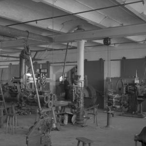 Paja, jossa on koneita ja ihmiset työskentelevät niiden ympärillä.