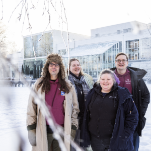 Four people look at the camera in Sorsapuisto in winter.