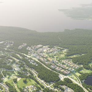 Laaja ilmakuva, jossa takana järvi ja uusi asuinalue keskellä.