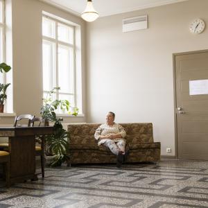 Annamaija Saarela istuu sohvalla Nekalan kulttuurikeskuksen käytävällä.