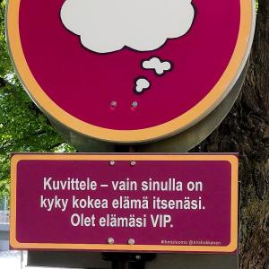 Punaisia liikennemerkin tyylisiä kylttejä puun kyljessä. 