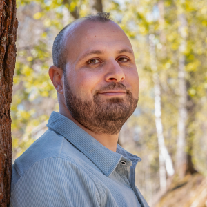 Husam Al Tawalbeh leans against a tree in his own backyard.