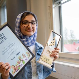 Hasanat Sultani presents her two prizes in a classroom at Hatanpää school.