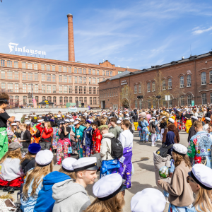 Satoja opiskelijoita koolla Frenckellin aukiolla vapputapahtumassa ylioppilaslakit päässään ja haalarit yllään.
