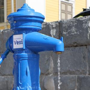 Water flows from the drinking water fountain at Keskustori, in front of the Vanha kirkko.