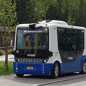 Robottibussi Hervantajärven pysäkillä. Taustalla ratikka.