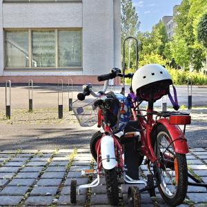 Kaksi pienten lasten polkupyörää koulun pihassa.
