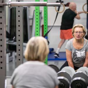 A woman is lifting weights at the gym.
