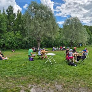 Ihmisiä ruokailemassa puistossa