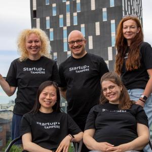 Elina Wallin (left), Ville Brusi, Mia Häkkinen, Shanshan Du, and Tredun's Abigeil Varuhin pose as a group on the rooftop terrace of Startup.Tampere.