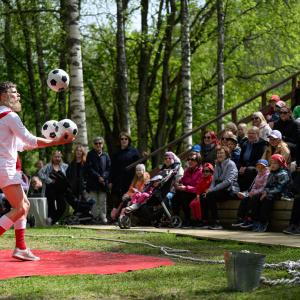 Sirkustaiteilija jongleeraa palloja.