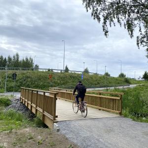Vähäjärvenpuiston silta, jota ylittää pyöräilijä.