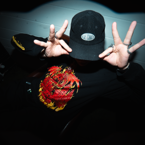 Rap-artisti Nelikasi näyttää lippalakkiaan.