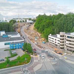 Kuvassa katu, jossa työmaa. Ympärillä rakennuksia ja vihreyttä.