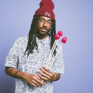 Joel Ross, vibraphone mallets in hand and a Monk beanie on his head.