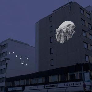 Havainnekuva kuva pimeästä, jossa talojen seinille on heijastettu kuvia.