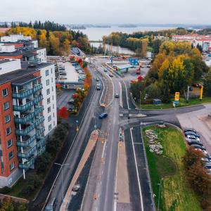 Kuvassa raitiotietyömaa, katua, taloja ja pysäköityjä autoja. 