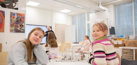 Children in a classroom at a table. 