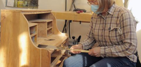 Henkilö entisöi lipastoa.