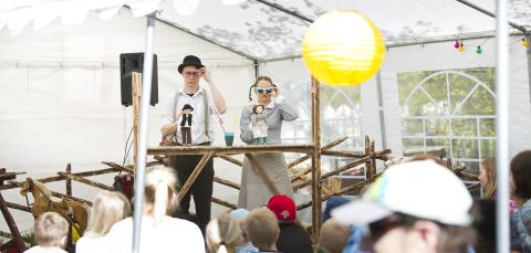 Mies ja nainen esiintymässä käsissään nuket.