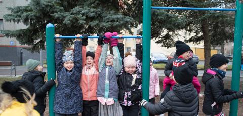 Children hang outside on a rack.
