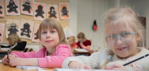 Children in class with school books.
